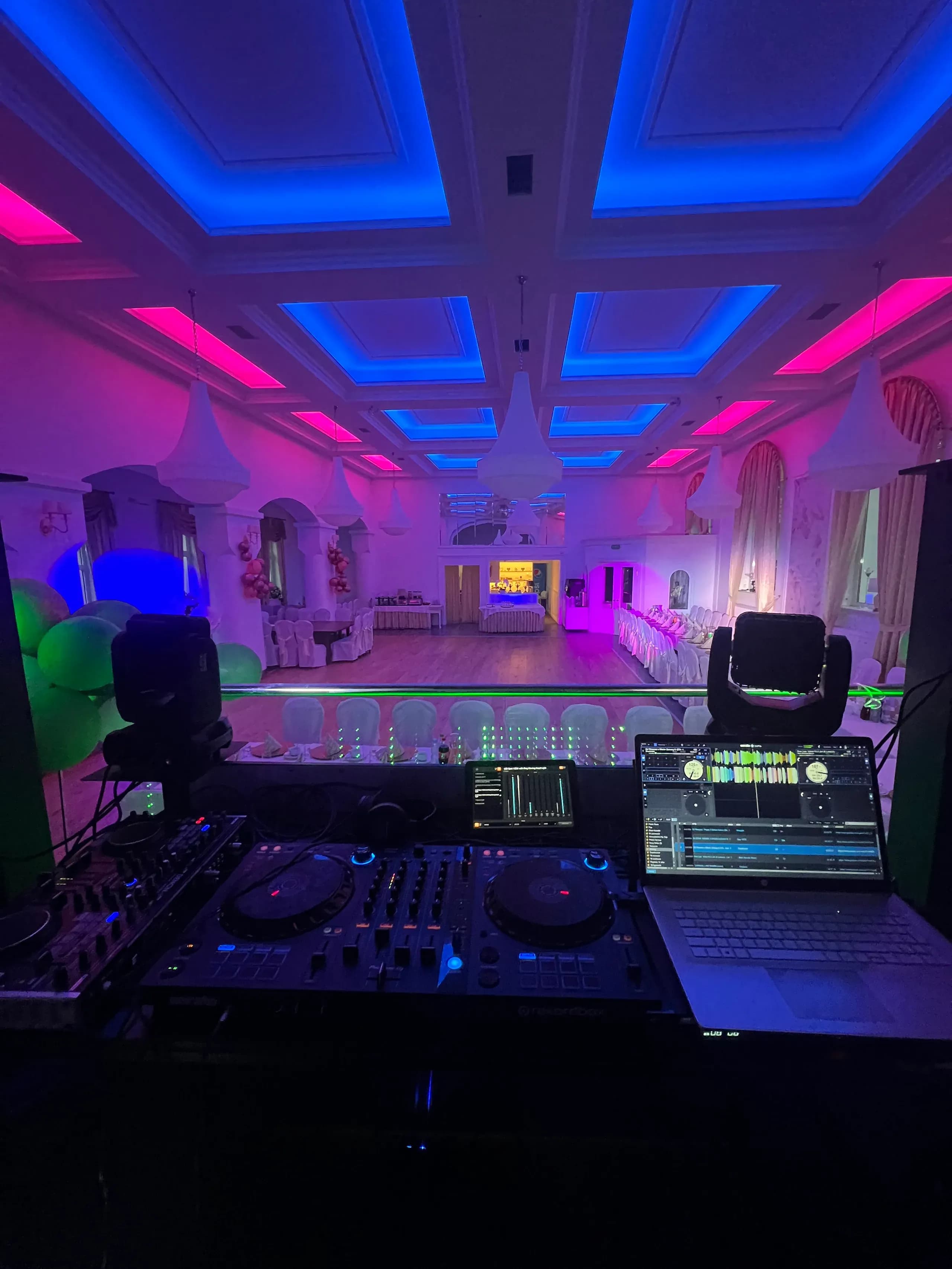 Konsoleta DJ-a i kolorowe oświetlenie sali weselnej