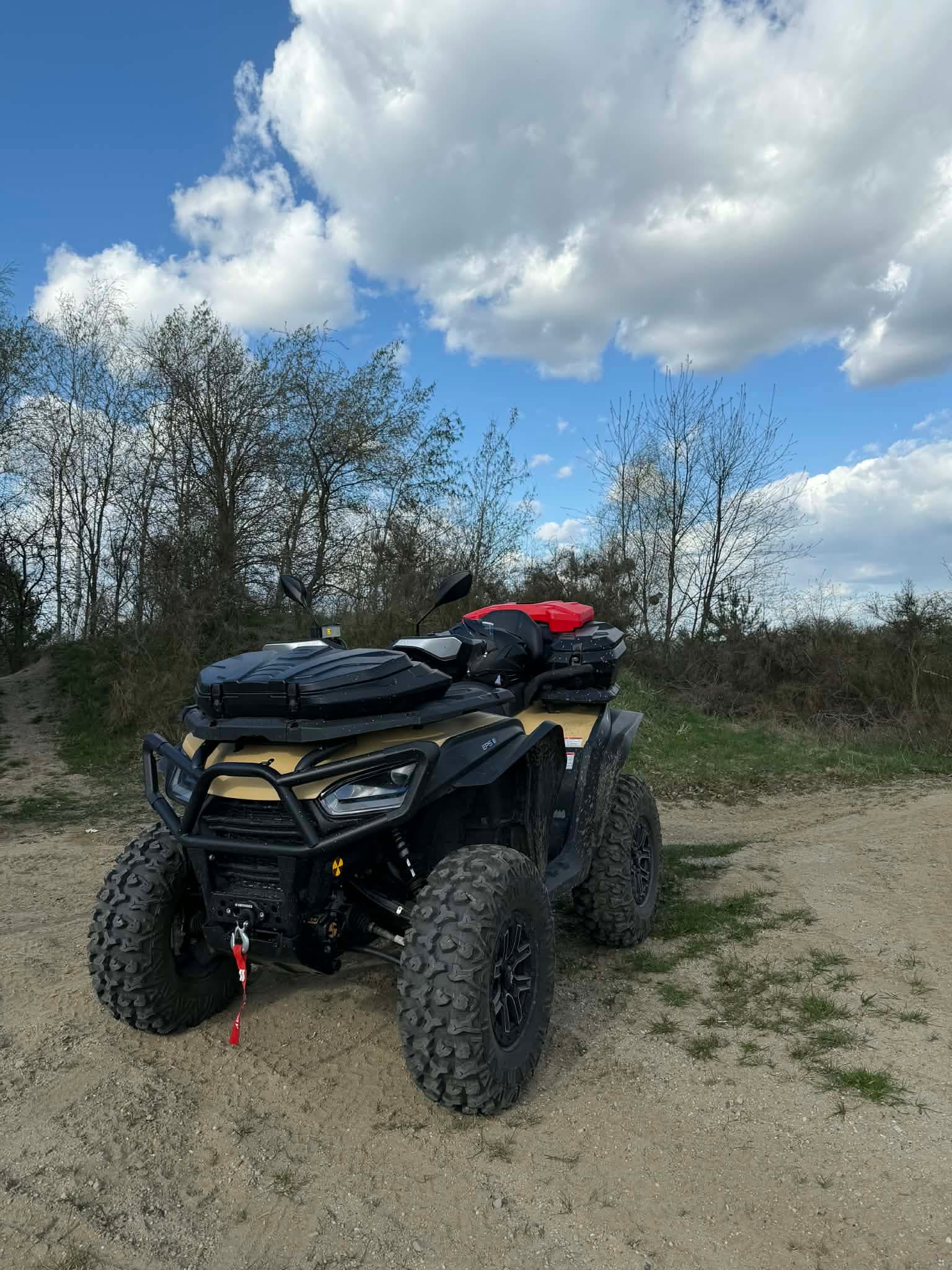 Quad terenowy na tle drzew i błękitnego nieba