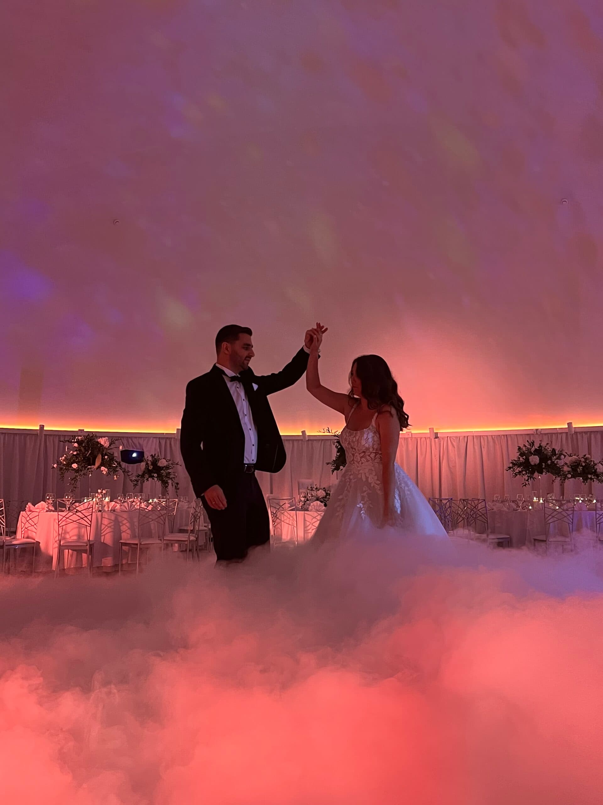 Pierwszy taniec pary młodej w gęstym dymie podświetlonym na różowo